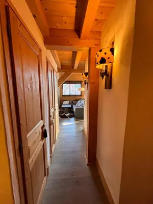 a hallway leading to a living room with a door and a room with at Appartement duplex megeve in Megève