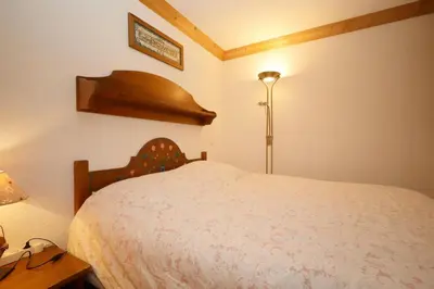 a bedroom with a bed and a lamp and a table at Résidence Les Hauts De Chavants - Hauts de chavants Albert 1er n°3 MAE-2651 in Les Houches