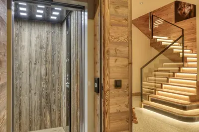 a hallway with a wooden door and stairs at Chalet Ascension in Combloux