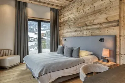 a bedroom with a bed and a wooden wall at Chalet Ascension in Combloux