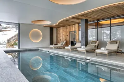a pool in a house with chairs and windows at Chalet Ascension in Combloux