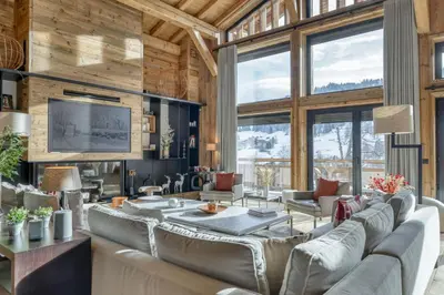 a living room with leather couches and a television at Chalet Alpes in Combloux