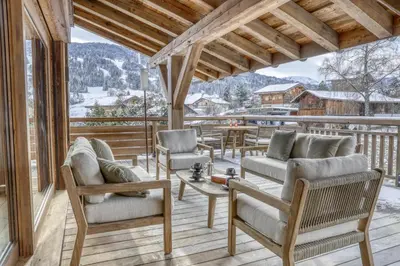 a porch with chairs and a table on a deck at Chalet Alpes in Combloux