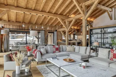 a living room with white furniture and wooden ceilings at Chalet Alpes in Combloux