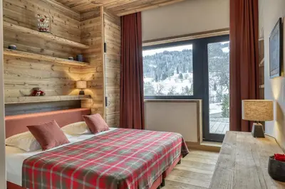 a bedroom with a bed and a large window at Chalet Alpes in Combloux