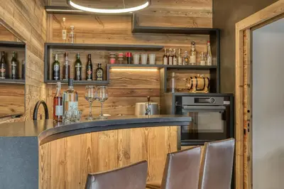 a bar with a counter with wine glasses at Chalet Alpes in Combloux
