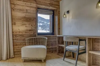 two chairs and a bar in a room with a window at Chalet Alpestre in Combloux
