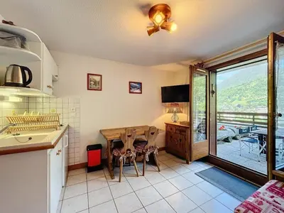a kitchen with a table and a dining room at Studio Le Flocon à Saint-Gervais-les-Bains in Saint-Gervais-les-Bains