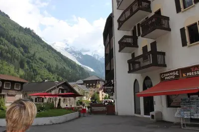 a woman is looking out at the mountains from a building at Batiment F - A Chamonix Mont Blanc Panorama in Chamonix-Mont-Blanc