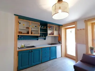 a kitchen with blue cabinets and a pendant light at Au petit Névé in Les Houches