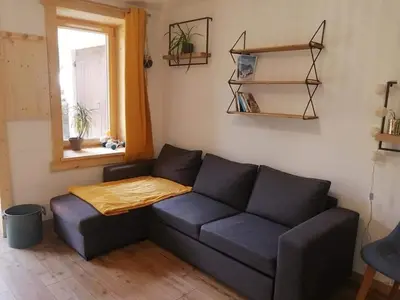 a living room with a blue couch and a window at Au petit Névé in Les Houches