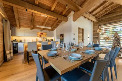 a dining room with a long wooden table and chairs at Le Chalet Baan - avec vue sur les montagnes in Combloux