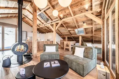 a living room with wooden ceilings and a table and chairs at Chalet 4 Mésanges, Saint-Gervais -Le Bettex - by EMERALD STAY in Saint-Gervais-les-Bains