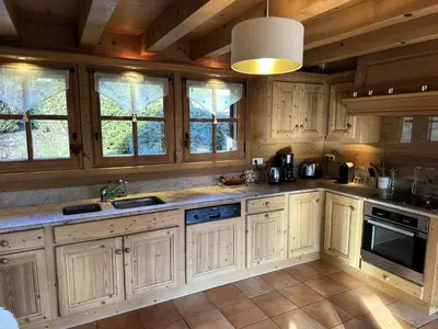 a large kitchen with wooden cabinets and windows at Chalet Medonnet - CHALET 10 personnes Combloux MAE-7241 in Combloux