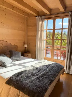a bedroom with a large bed and a large window at Chalet Medonnet - CHALET 10 personnes Combloux MAE-7241 in Combloux