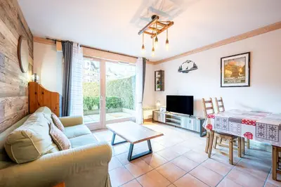 a living room with a couch and a table at Le Regency - à 5 min à pied des pistes in Saint-Gervais-les-Bains