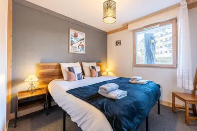 a bedroom with a large bed with towels on it at Le Regency - à 5 min à pied des pistes in Saint-Gervais-les-Bains