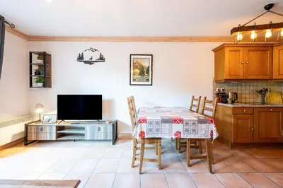 a kitchen and dining room with a table and chairs at Le Regency - à 5 min à pied des pistes in Saint-Gervais-les-Bains