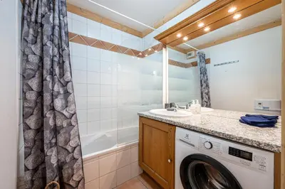 a bathroom with a washing machine and a sink at Le Regency - à 5 min à pied des pistes in Saint-Gervais-les-Bains
