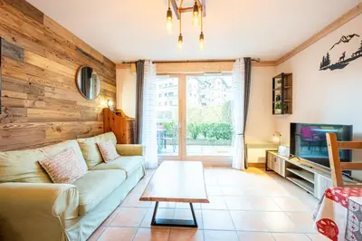 a living room with a couch and a tv and a table at Le Regency - à 5 min à pied des pistes in Saint-Gervais-les-Bains
