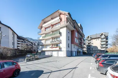 a building with cars parked in a parking lot at Le Regency - à 5 min à pied des pistes in Saint-Gervais-les-Bains