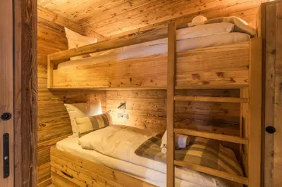 a bedroom with two bunk beds in a log cabin at Appartement Mady - Welkeys in Megève