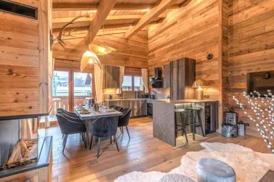 a kitchen and dining room with a table and chairs at Appartement Mady - Welkeys in Megève