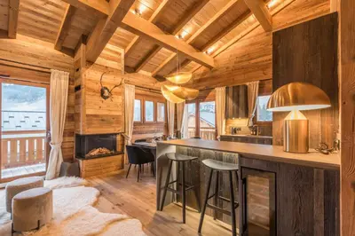 a kitchen with a large island in a log cabin at Appartement Mady - Welkeys in Megève