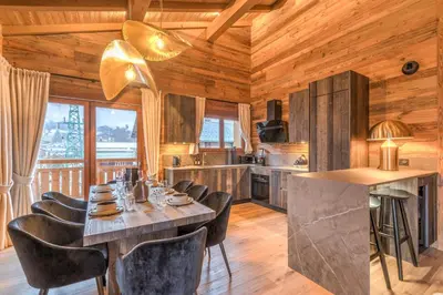a kitchen and dining room with a table and chairs at Appartement Mady - Welkeys in Megève