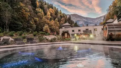a swimming pool in front of a house with a mountain at Appartement avec vue magnifique in Saint-Gervais-les-Bains