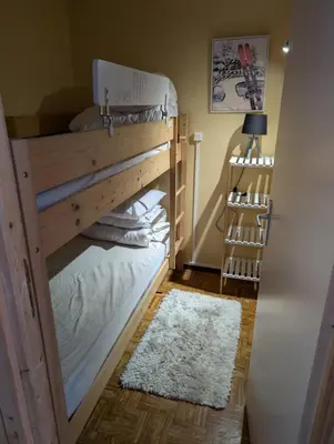 a bunk bed in a room with a white rug at Appartement avec vue magnifique in Saint-Gervais-les-Bains