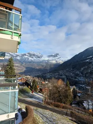 a view from the balcony of a building with snow covered mountains at Appartement avec vue magnifique in Saint-Gervais-les-Bains