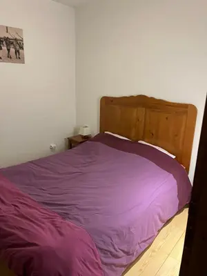 a purple bed with a wooden headboard in a bedroom at Samoëns 2 in Samoëns