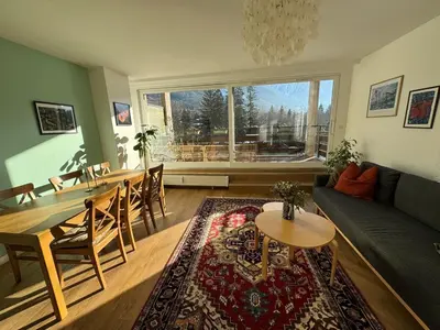 a living room with a couch and a dining room table at MontBlancViewApartment in Chamonix-Mont-Blanc