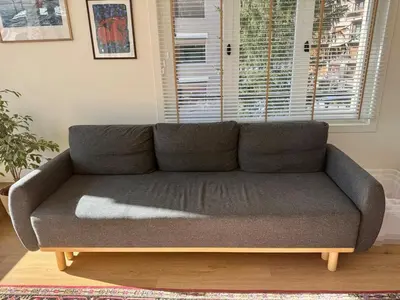 a gray couch in a living room with a window at MontBlancViewApartment in Chamonix-Mont-Blanc
