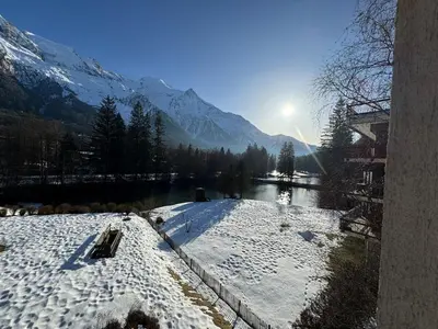 a snow covered mountain with the sun in the background at MontBlancViewApartment in Chamonix-Mont-Blanc