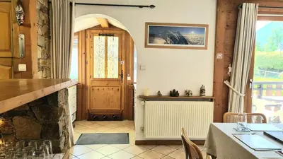 a dining room with a table and a door at Apartment Plan de l'Aiguille - Garden Chx Center in Chamonix-Mont-Blanc