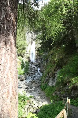 a waterfall in the middle of a river in a forest at Apartment Plan de l'Aiguille - Garden Chx Center in Chamonix-Mont-Blanc
