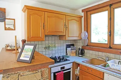 a kitchen with wooden cabinets and a picture on the counter at Apartment Plan de l'Aiguille - Garden Chx Center in Chamonix-Mont-Blanc