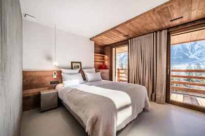 a bedroom with a large bed and a large window at Chalet Foxden, Les Houches Chamonix - by EMERALD STAY in Les Houches