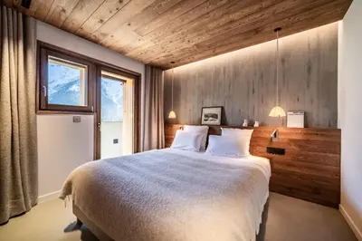 a bedroom with a large bed with wooden walls at Chalet Foxden, Les Houches Chamonix - by EMERALD STAY in Les Houches