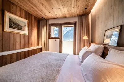 a bedroom with a bed in a wooden wall at Chalet Foxden, Les Houches Chamonix - by EMERALD STAY in Les Houches