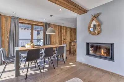 a dining room with a fireplace and a table and chairs at RUBY - Luxurious duplex 180 m2 in Chamonix-Mont-Blanc