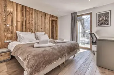 a bedroom with a large bed with wooden walls at RUBY - Luxurious duplex 180 m2 in Chamonix-Mont-Blanc