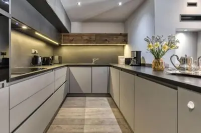 a kitchen with white cabinets and black counter tops at RUBY - Luxurious duplex 180 m2 in Chamonix-Mont-Blanc