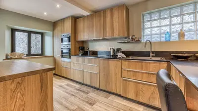 a kitchen with a large island with leather chairs at Chalet Grelettes in Les Houches