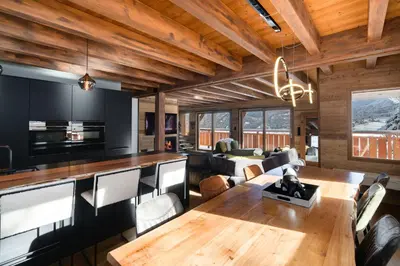 a dining room and living room with a table and chairs at La Combe Blanche - Balcon sur le Mont-Blanc in Combloux