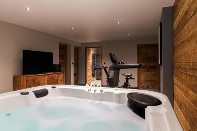 a large white bath tub in a room with a gym at La Combe Blanche - Balcon sur le Mont-Blanc in Combloux