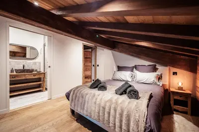 a bedroom with a large bed and a sink at La Combe Blanche - Balcon sur le Mont-Blanc in Combloux