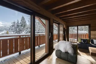 a living room with a couch and a large window at La Combe Blanche - Balcon sur le Mont-Blanc in Combloux